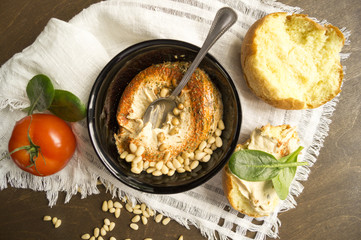 hummus appetizer with pine nuts on wooden table