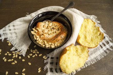 hummus appetizer with pine nuts on wooden table