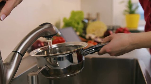 Woman is going to prepare vegetable salad in the kitchen.
