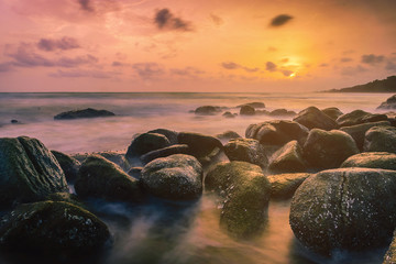 Fototapeta na wymiar Sunset on the coast of the Thailand at dawn with rocks in foreground.