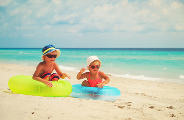 cute little boy and toddler girl play on beach