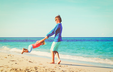 father and little daughter play at beach