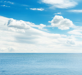 Naklejka na ściany i meble blue sea and sky with white clouds over it