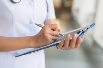 image of woman nurse in white coat report in a notebook