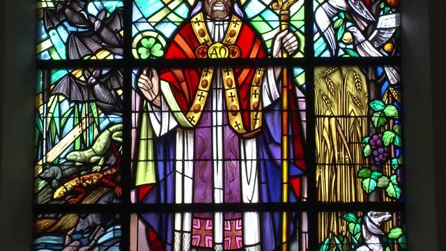 Bemaltes Kirchenfenster mit Heiligenfigur mit Bischofsstab (vertikaler Kameraschwenk)