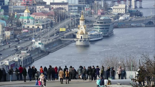 Ukraine, Kiev, Podil. Promenade on the river Dnieper. People admire the view of the river, and near the rushing cars on the highway