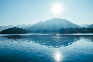 Fototapeta premium Beautiful landscape mountain ,sun and flare in the lake at morning time , Chaing Mai Thailand. Filter effect