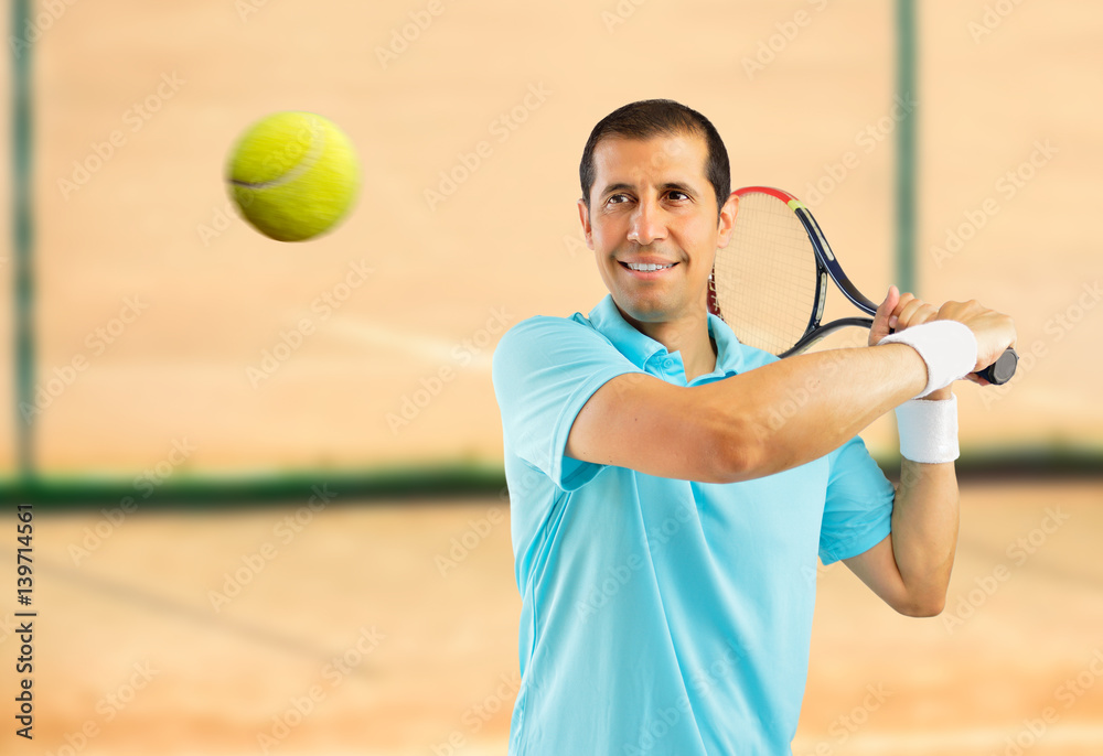 Canvas Prints portrait of a male tennis player swatting the ball on a clay court