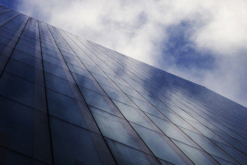Obraz na płótnie Canvas Business building with sky and clouds reflection