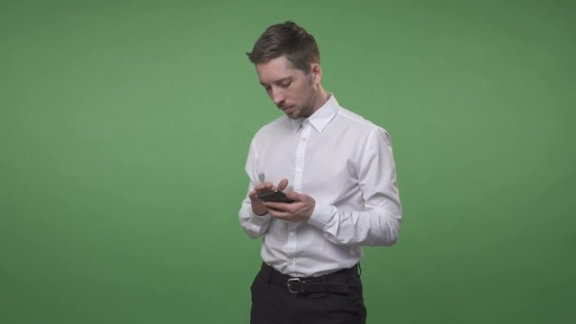 Young handsome man using his smartphone, chroma key green screen background
