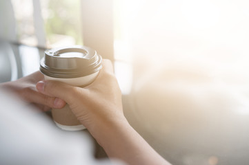 Close up of woman hands holding cup of coffee.