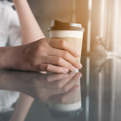 Close up of woman hand holding cup of coffee.