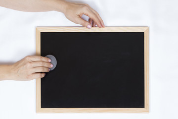 Hands of woman holding and erasing an empty handboard
