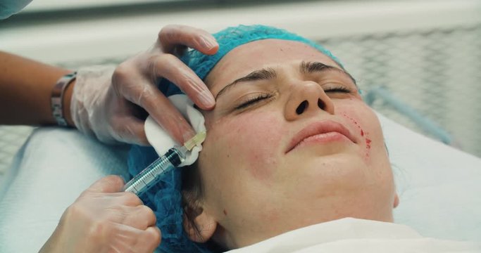 4k Close-up of a young woman having botox injection in the beauty salon