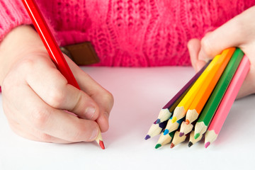 Child draws with colored pencils