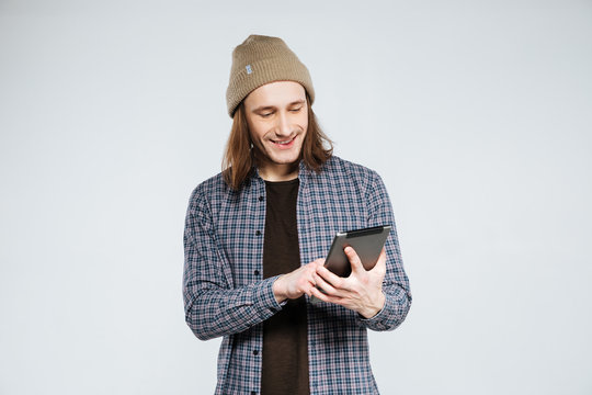 Smiling hipster using tablet computer