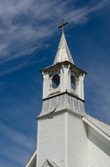 Fototapeta na wymiar Old white church steeple and blue skies