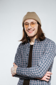 Vertical image of Smiling hipster in eyeglasses with crossed arms