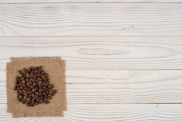Coffee beans on sacking and an old white table.