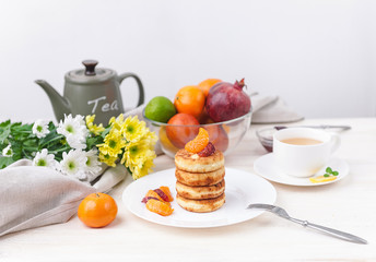 cheese pancake with citrus fruits and jam on a wooden table with tea. Breakfast concept