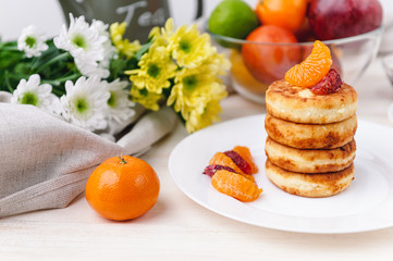 cheese pancake with citrus fruits and jam on a wooden table with tea. Breakfast concept