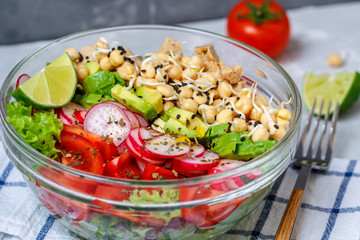 Colorful vegetable salad with tofu, chickpeas, avocado in a glass bowl. Love for a healthy vegan food concept