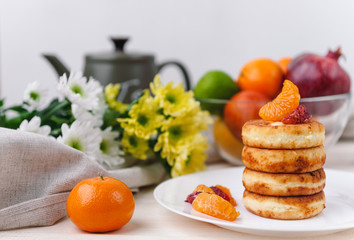 cheese pancake with citrus fruits and jam on a wooden table with tea. Breakfast concept