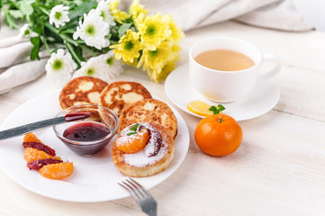 cheese pancake with citrus fruits and jam on a wooden table with tea. Breakfast concept