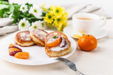 cheese pancake with citrus fruits and jam on a wooden table with tea. Breakfast concept