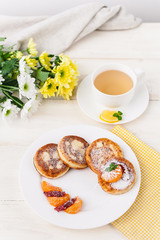 cheese pancake with citrus fruits and jam on a wooden table with tea. Breakfast concept