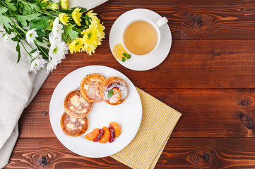 cheese pancake with citrus fruits and jam on a wooden table with tea. Breakfast concept