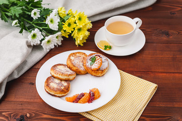 cheese pancake with citrus fruits and jam on a wooden table with tea. Breakfast concept