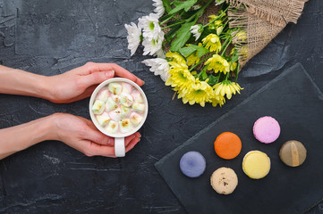 Macarons and mug with hot chocolate and marshmallows