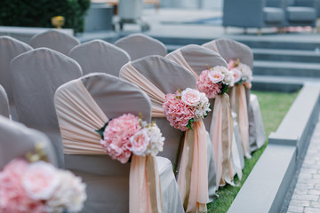 Wedding chairs decorated with bouquets of flowers