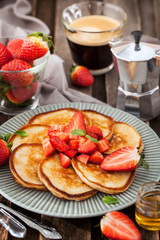 Homemade delicious pancakes served with fresh strawberries and honey