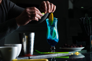 bartender in a nightclub pouring cocktail
