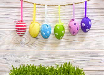 Colorful easter eggs hanging on rustic wooden background with space. easter eggs background