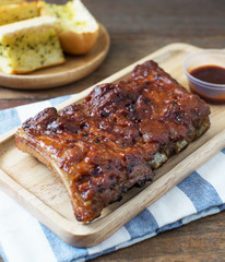 pork ribs barbecue with garlic bread on wood table