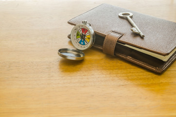 Compass and brown leather organizer with key
