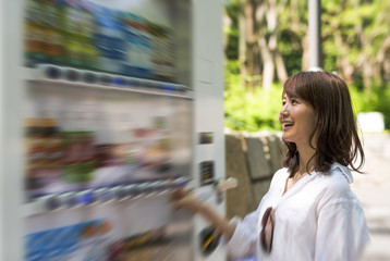 Beautiful asian woman selecting beverage at vending machine outdoor