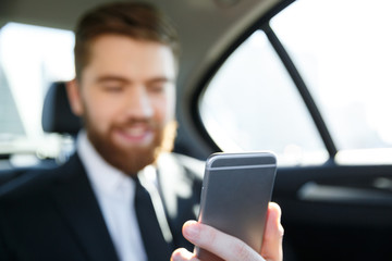 Man in suit looking at mobile phone in his hand