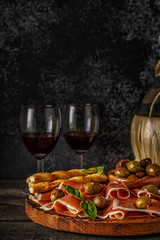 Prosciutto, cracker, bread sticks with red wine.