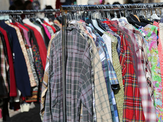 clothes hung from hangers for sale in flea market