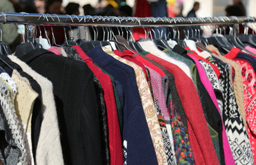 clothes hung from hangers for sale in flea market