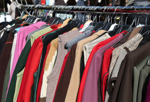 clothes hung from hangers for sale in flea market
