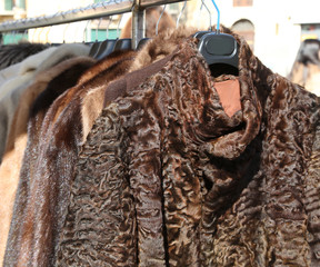 fur coats and clothes for sale in the hanger in the flea market