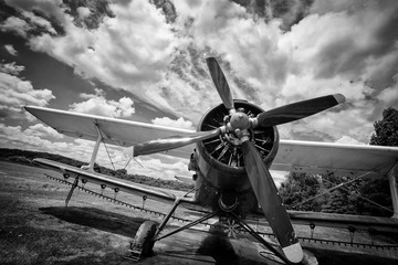 Oud vliegtuig op veld in zwart-wit