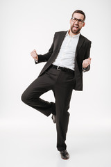Handsome happy young bearded businessman make winner gesture.