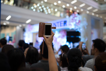 People hand using smartphone taking photo in concert
