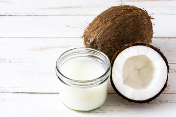 Coconut and coconut milk on white wooden table
